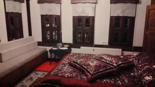 a bedroom with a bed with a red blanket and windows at Çamlıca Konak Çarsı in Safranbolu