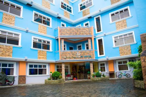 a blue building with white windows at Royal Mansion Hotel in Tabaco