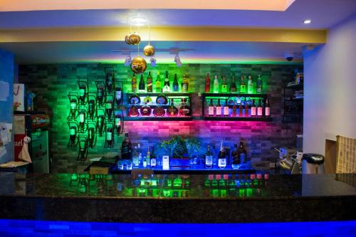 a bar with green bottles on a brick wall at Royal Mansion Hotel in Tabaco