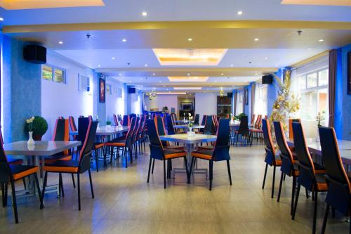 a dining room with tables and chairs in a restaurant at Royal Mansion Hotel in Tabaco