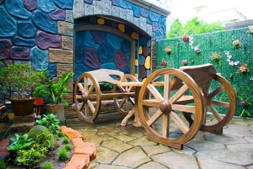 a patio with two wooden wagon wheels next to a wall at Royal Mansion Hotel in Tabaco