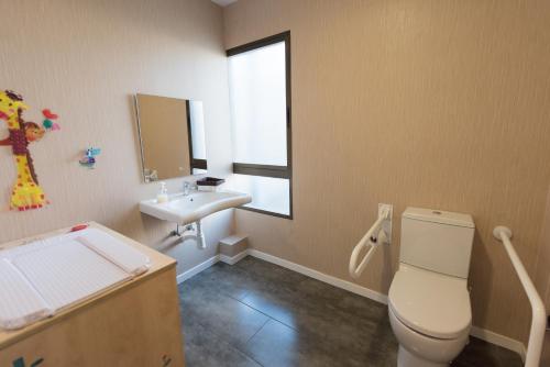 a bathroom with a toilet and a sink and a window at Las Ventas in Utebo