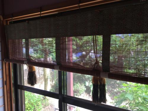 a window with a view of a bird in a cage at Masugataya Ryokan in Tako