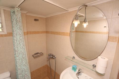 a bathroom with a shower and a sink and a mirror at Iris Seafront Apartments in Fourka