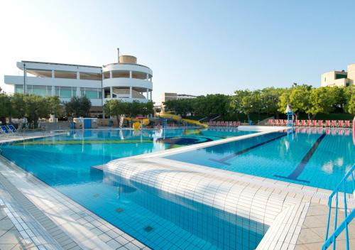 a large swimming pool with blue water in front of a building at Corvino Resort in Monopoli