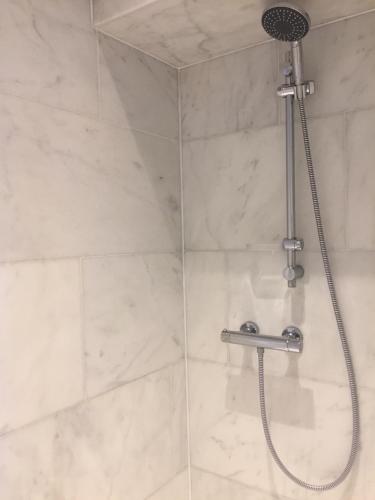 a shower with a shower head in a bathroom at Hotel Royal Astrid in Aalst