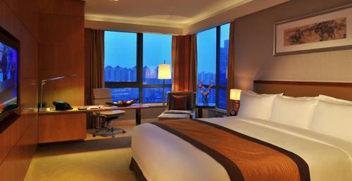 a hotel room with a bed and a desk and window at Royal Mansion Hotel in Tabaco