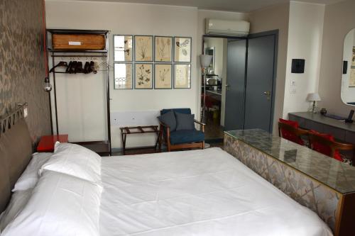 a bedroom with a white bed and a desk at Ca' Monteggia Guest House in Milan