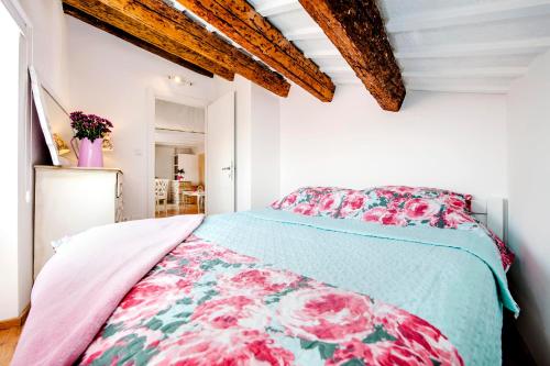 a bedroom with a bed with a floral bedspread at Apartment Casa Alek in Rovinj