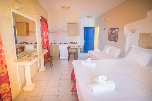a living room with two beds and a kitchen at Parthenis Hotel & Suites in Malia