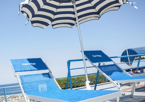 a pair of chairs and an umbrella on a boat at Corvino Resort in Monopoli