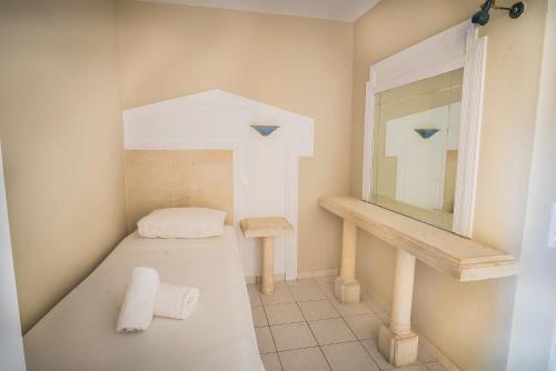a small bathroom with a sink and a mirror at Parthenis Hotel & Suites in Malia