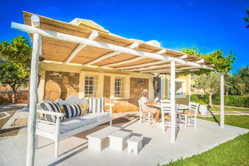 a pergola on a patio with a table and chairs at Parthenis Hotel & Suites in Malia
