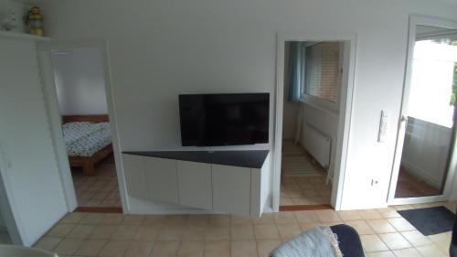 een woonkamer met een tv aan een witte muur bij plattedijk 25-47 in Lemmer