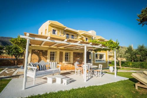 a patio with chairs and a table in front of a house at Parthenis Hotel & Suites in Malia