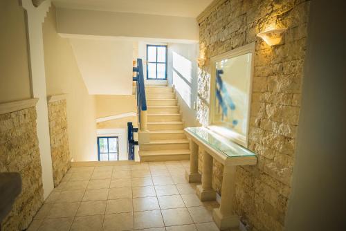 a hallway with stairs and a stone wall at Parthenis Hotel & Suites in Malia