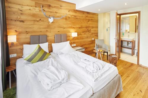 a large white bed in a room with wooden walls at Die Reichsstadt - Hotel Spa und Restaurant in Gengenbach