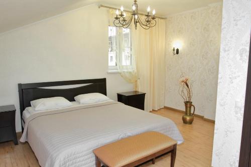 a bedroom with a large white bed with a chandelier at Apartment on Malaya Troitskaya 13 in Grodno