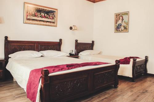 two beds sitting next to each other in a bedroom at Hotel Kastro in Gjirokastër