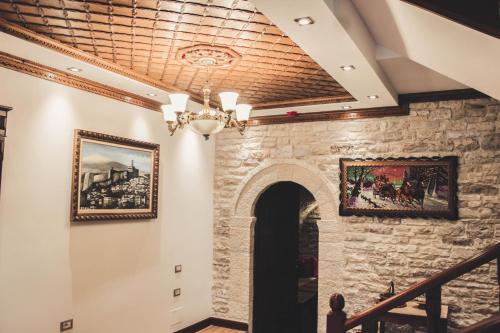 a room with a stone wall and a chandelier at Hotel Kastro in Gjirokastër