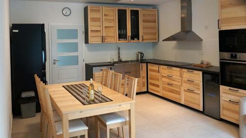 eine Küche mit einem Holztisch mit Stühlen und eine Küche mit schwarzen Geräten in der Unterkunft Apartmány U Zámečku in Hlohovec