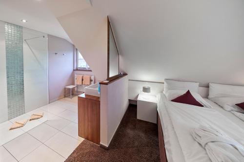 a bedroom with a bed and a walk in shower at Die Reichsstadt - Hotel Spa und Restaurant in Gengenbach
