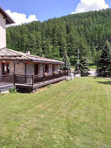 a house with a large yard next to a forest at Hotel Banchetta in Sestriere