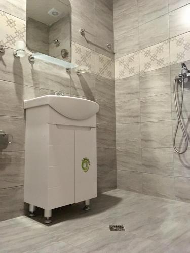 a bathroom with a white sink and a mirror at Guest House Urdoviza in Kiten