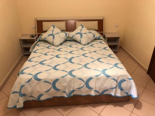 a bed with a blue and white comforter and pillows at Double Room with Terrace in Golem