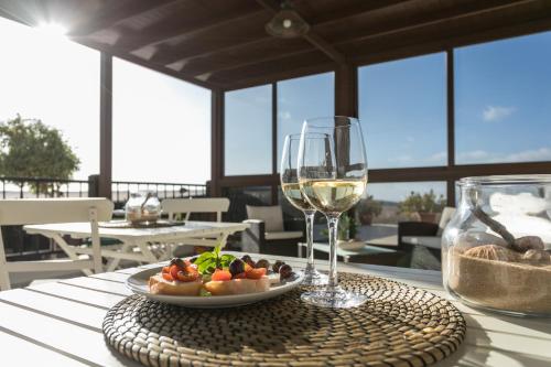 una mesa con un plato de comida y una copa de vino en Villa El Jable Lanzarote en Teguise