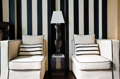 two chairs and a lamp in a room with striped walls at Casa Montani in Rome