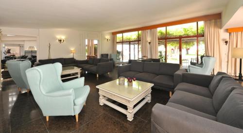 a living room with couches and chairs and a table at Hotel Salobreña Suites in Salobreña