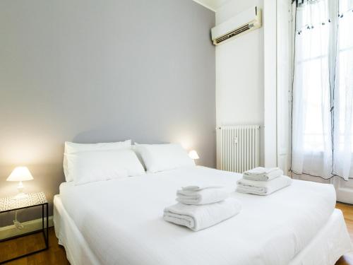 ein Schlafzimmer mit einem großen weißen Bett mit Handtüchern darauf in der Unterkunft easyhomes-Majno in Mailand