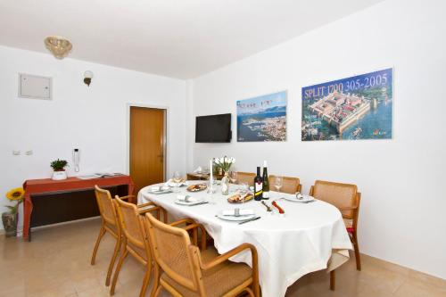 een eetkamer met een witte tafel en stoelen bij Apartment Topic near the beach in Podstrana