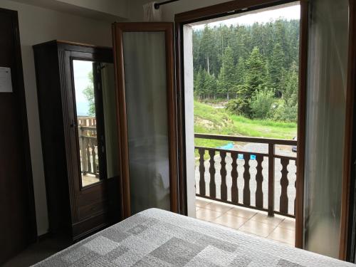 a bedroom with a door open to a balcony at Le Ranch in La Bollène-Vésubie