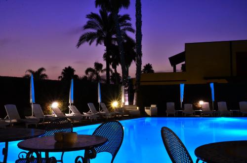 - Piscina resort con mesas y sillas por la noche en Hotel Agora Sure Hotel Collection by Best Western, en Lago Patria