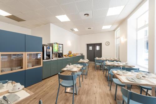 une salle à manger avec des tables et des chaises bleues dans l'établissement Residhotel Vieux Port, à Marseille