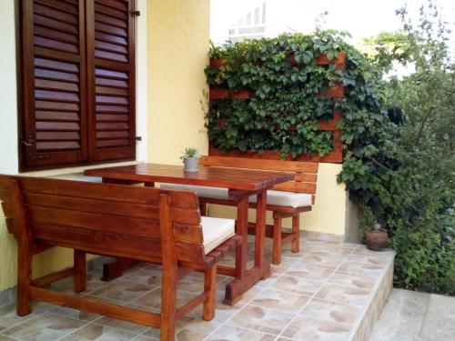 a wooden table and benches sitting on a patio at Apartments Phoenix in Ivanica