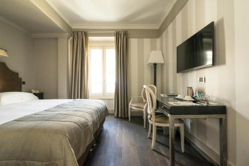 a hotel room with a bed and a desk at Casa Montani in Rome