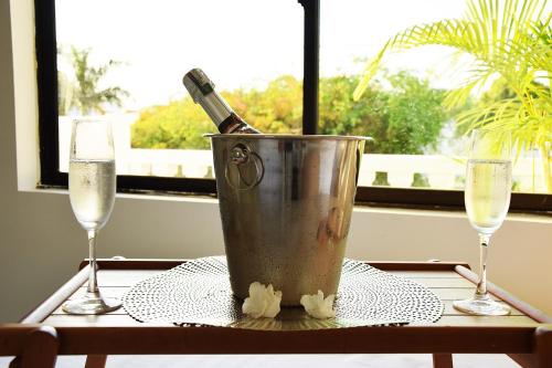 a bucket with a bottle of champagne on a table with two glasses at Mucura Hotel & Spa in Cartagena de Indias