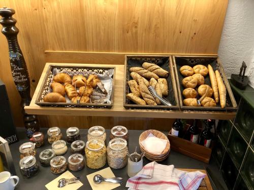 a table topped with trays of bread and other foods at Aparthotel Pfeffermühle in Ramsau am Dachstein