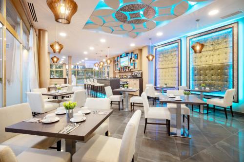 a dining room with tables and white chairs at Hotel Admiral San Roque in San Roque