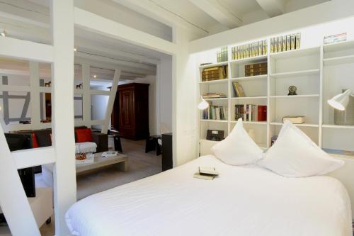 - une chambre avec un lit blanc et des étagères blanches dans l'établissement COLMAR city center place de l'Ancienne Douane - Apartment 