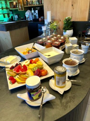 a table topped with plates of fruit and other food at Aparthotel Pfeffermühle in Ramsau am Dachstein
