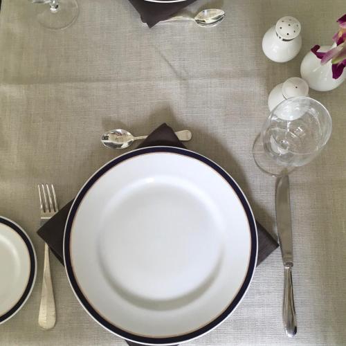 a table with two plates and a fork and a glass at Le Colonial 1506 - Exclusive Luxury Hideaway in Cochin