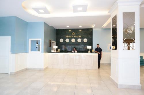 a man standing at the counter of a fashion store at Bursa Palas Hotel in Bursa