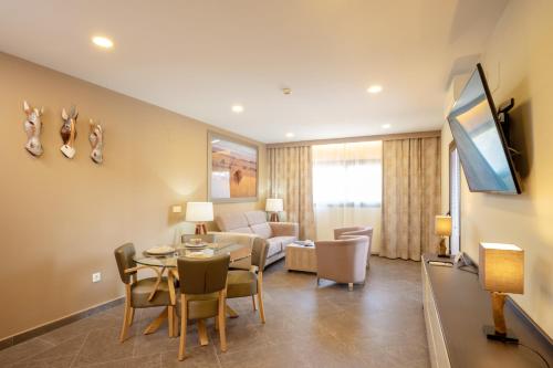 a living room with a couch and a table with chairs at Hotel Admiral San Roque in San Roque