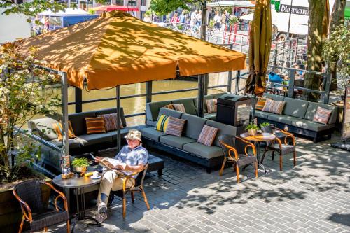 a person sitting at a table under an umbrella at Boutique Hotel Catshuis in Leeuwarden