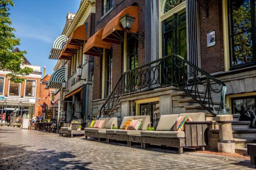 eine Reihe von Bänken auf einer Straße neben einem Gebäude in der Unterkunft Boutique Hotel Catshuis in Leeuwarden