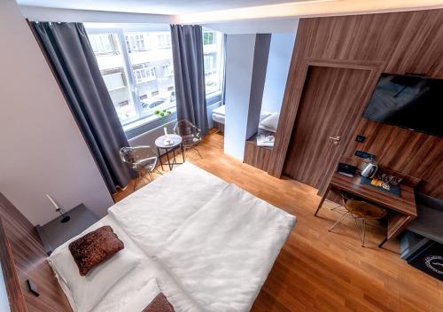 ein Schlafzimmer mit einem großen weißen Bett in einem Zimmer in der Unterkunft Atelier Hotel in Ljubljana